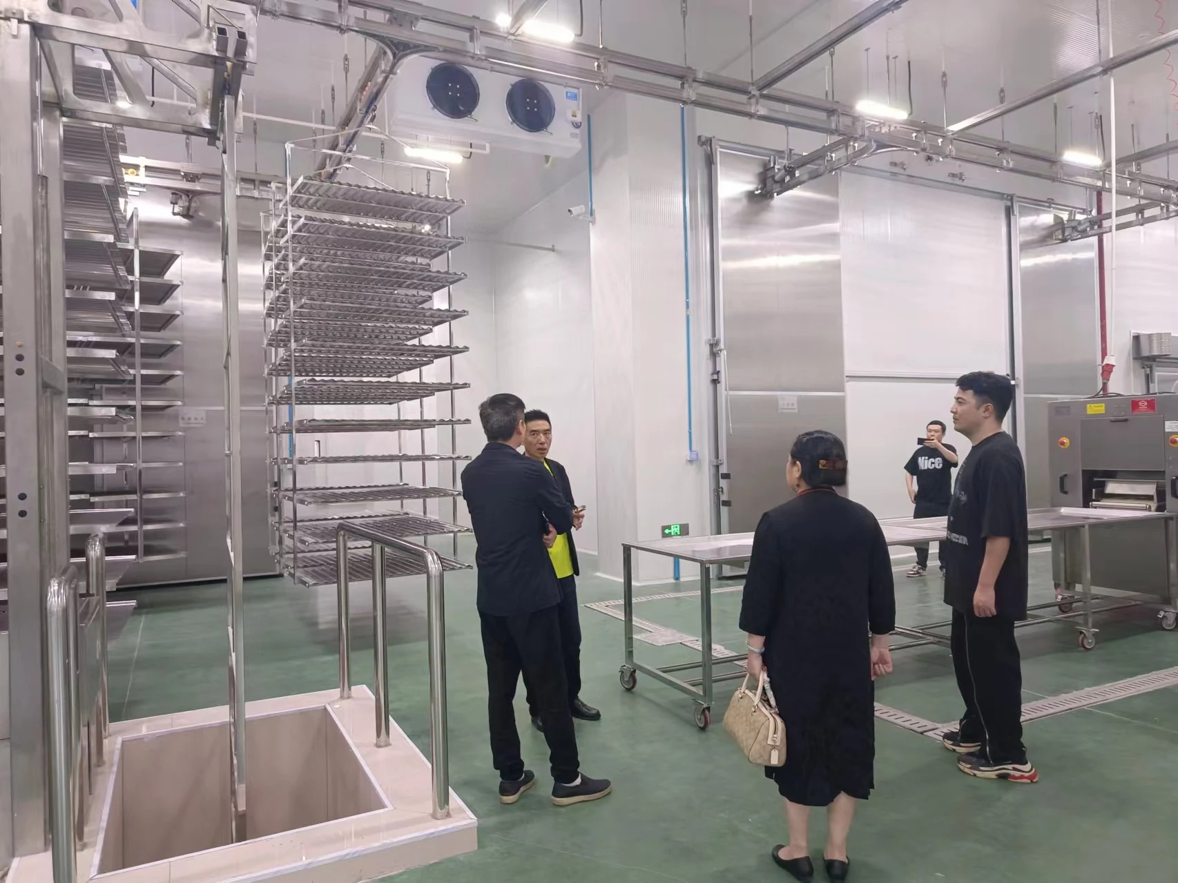 The delegation tours food-processing equipment inside the factory.