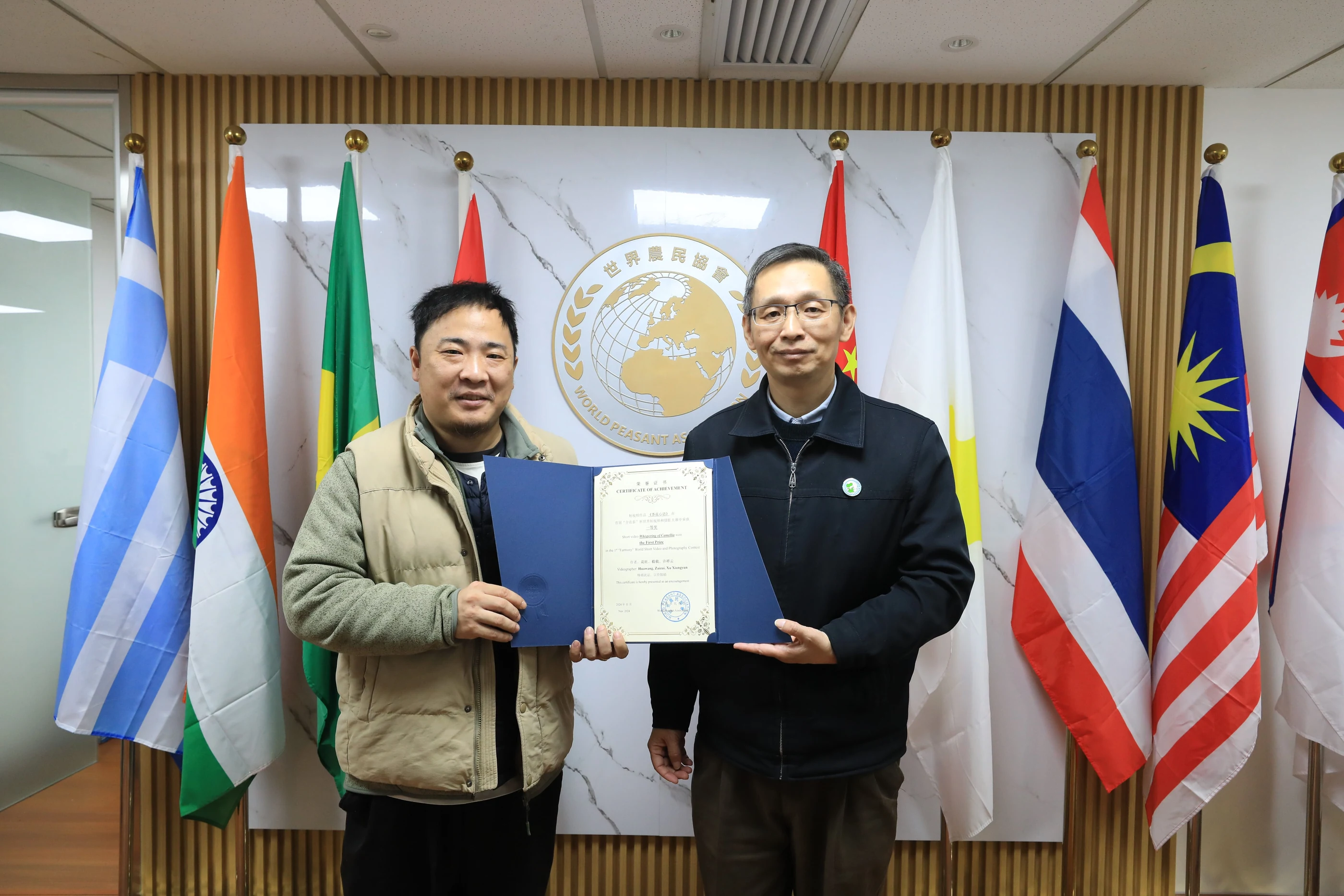 Director He Zairui receives an award certificate from Secretary General Zhang Qi.