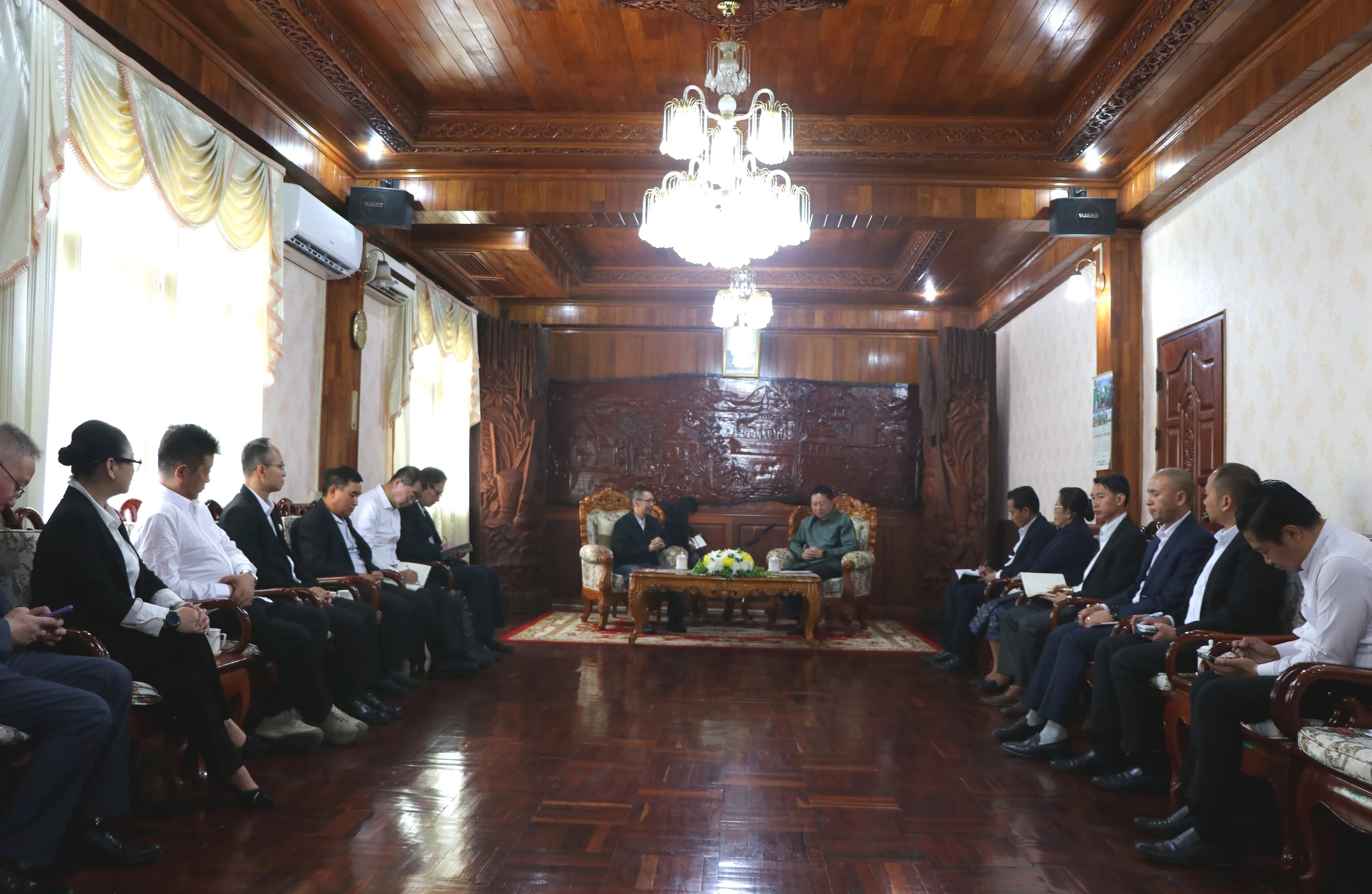 The two delegations sit together in the meeting room.