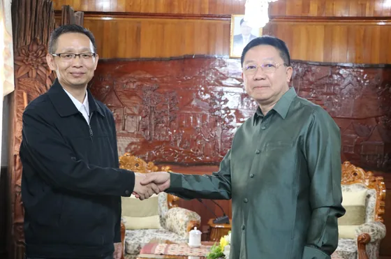 A handshake marks the agricultural-cooperation meeting in Vientiane.
