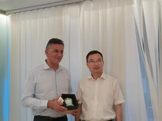 A presentation item is exchanged during the Jinhua visit.