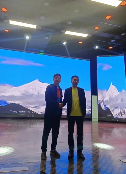 Two participants exchange a handshake in the live-streaming and presentation space.