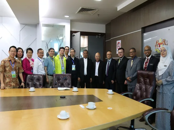 Participants gather around the conference table for a group photograph in Kuala Lumpur.