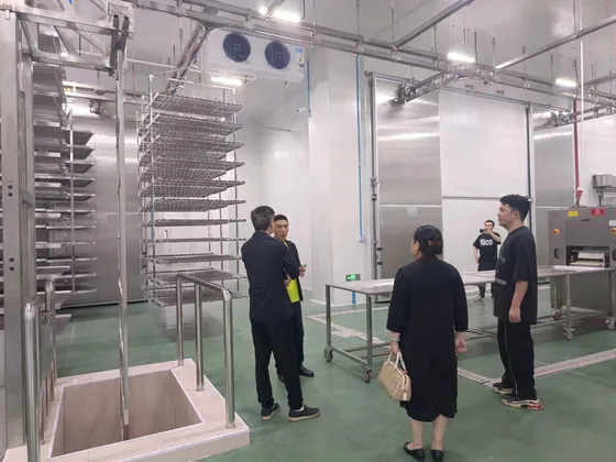 The delegation tours food-processing equipment inside the factory.