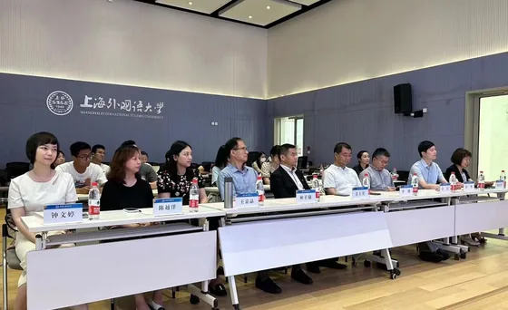 Participants listen from tables in the university meeting room.
