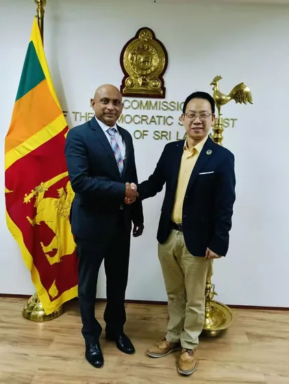 A handshake photograph beneath the Sri Lankan high commission emblem.