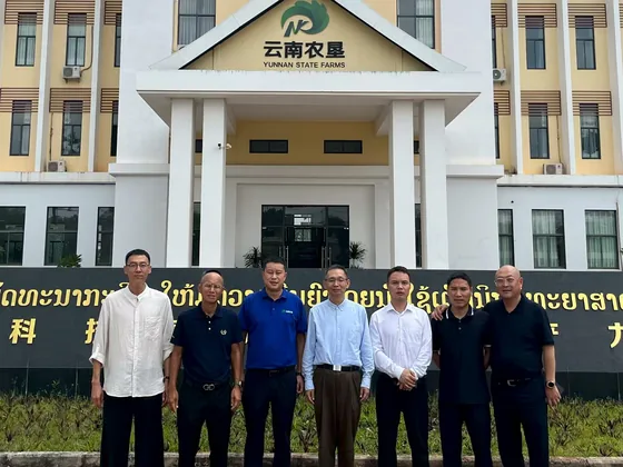 Delegation members stand outside the Yunnan State Farms facility in Laos.