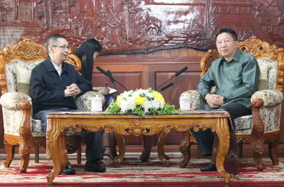 Delegation representatives discuss cooperation across a small table.