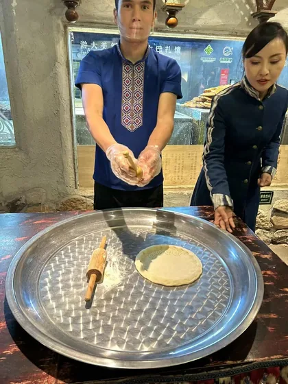 Visitors watch a flatbread-preparation demonstration during the trip.