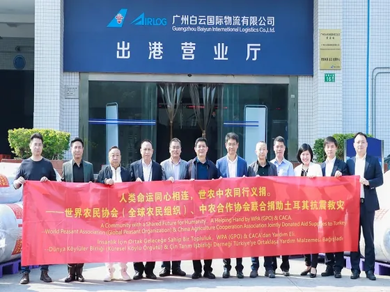 Participants hold the earthquake-relief banner outside the airport logistics office.