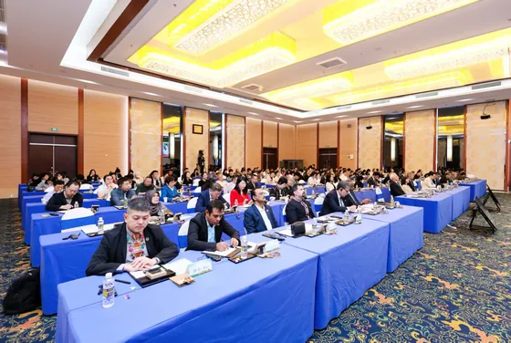 Delegates follow the programme at tables in the Hainan conference hall.