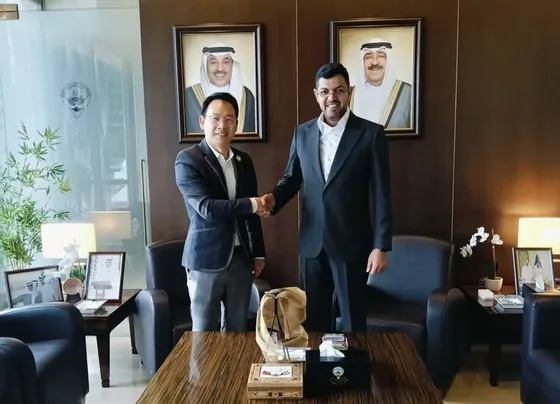 Participants exchange a handshake inside the Kuwaiti diplomatic office in Singapore.