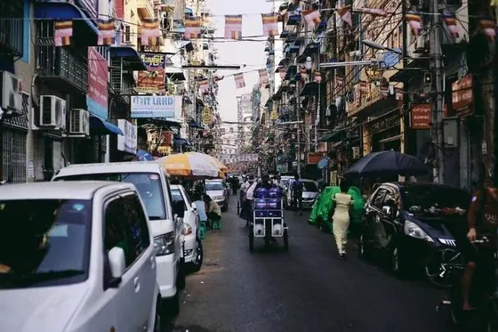 A busy Myanmar street with market activity and vehicles; contextual image accompanying the report.