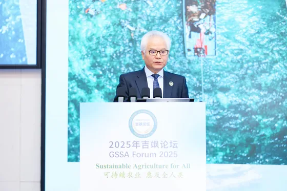 A forum speaker presents with a nature-themed backdrop.